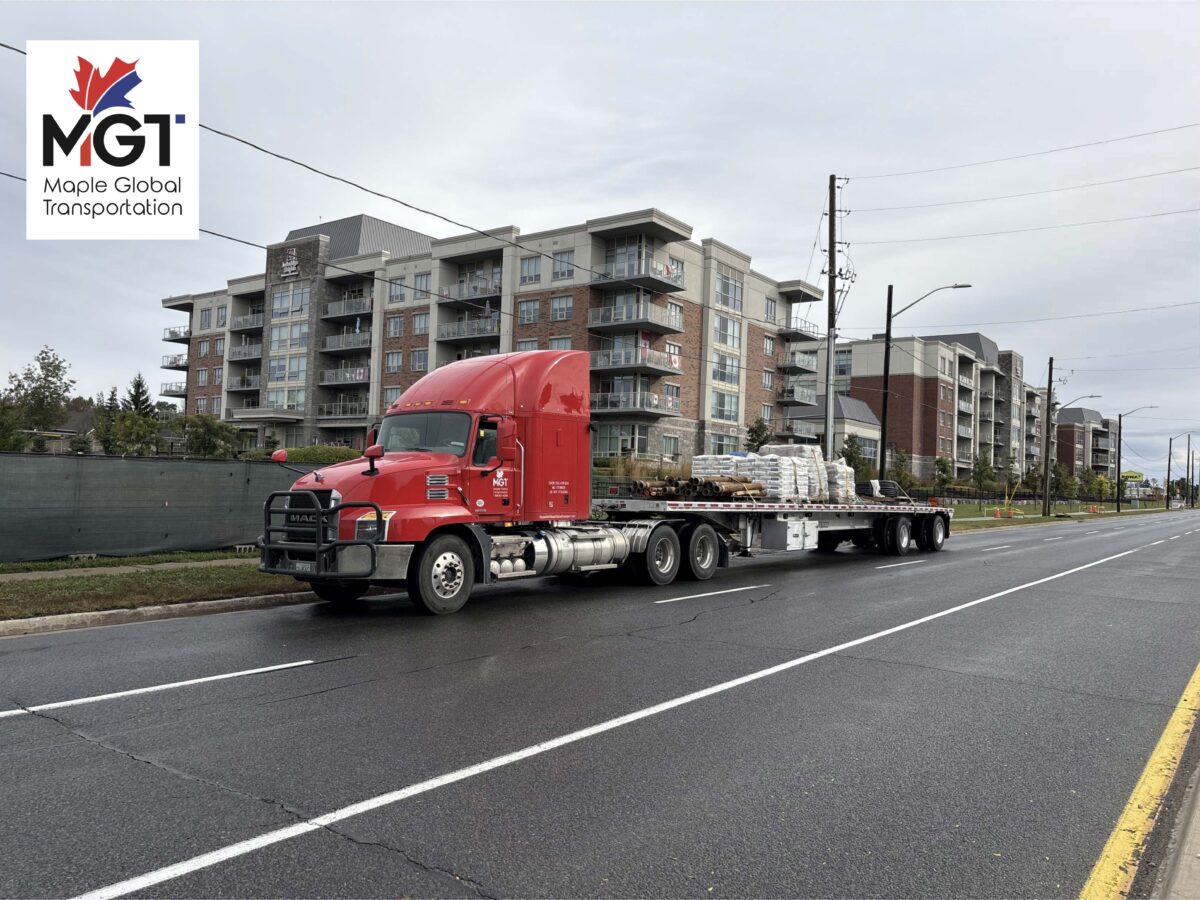 Maple Global Transport red semi truck hauling flatbed freight in Ontario