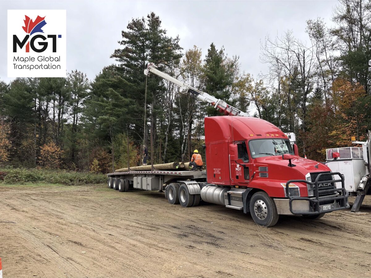 Maple Global Transport red semi-truck with flatbed trailer providing freight transportation services in Ontario.